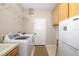 Functional laundry room with modern washer and dryer, storage cabinets, and utility sink at 7804 Edmonston Cir, University Park, FL 34201