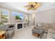 Cozy living room with a fireplace, built-in shelving, comfortable seating, and a ceiling fan at 7804 Edmonston Cir, University Park, FL 34201