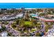 An aerial view highlighting the roundabout with a lush green space surrounded by city buildings and the beach at 800 S Blvd Of The Presidents # 19, Sarasota, FL 34236