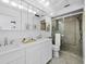 Bright bathroom features a double sink vanity and a large glass-enclosed shower with tile surround at 800 S Blvd Of The Presidents # 19, Sarasota, FL 34236