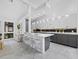 Modern kitchen with gray and white cabinets, an island with bar seating, and stainless steel appliances at 800 S Blvd Of The Presidents # 19, Sarasota, FL 34236