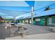 Charming outdoor dining area with blue canopies, concrete picnic tables, and a nearby snack bar with green accents at 800 S Blvd Of The Presidents # 19, Sarasota, FL 34236