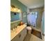 Bright bathroom featuring a shower with flower-themed curtain and a vanity with gold fixtures at 807 Mohawk Rd, Venice, FL 34293