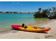 View of a kayak on a sandy beach with a blue waterway backdrop at 807 Mohawk Rd, Venice, FL 34293