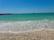 Scenic beachfront view with clear turquoise water meeting the sandy shore under a clear blue sky at 807 Mohawk Rd, Venice, FL 34293