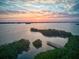 Breathtaking aerial view of the bay at sunset, showcasing the water and surrounding greenery at 8871 Fishermens Bay Dr, Sarasota, FL 34231