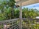 This is a balcony with a white lattice railing overlooking lush tropical foliage and trees at 8871 Fishermens Bay Dr, Sarasota, FL 34231