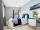 A cozy bedroom featuring a light color scheme, accent pillows, and modern desk at 8871 Fishermens Bay Dr, Sarasota, FL 34231