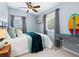 A serene bedroom with a light blue color scheme, surfboard art, and natural light from windows at 8871 Fishermens Bay Dr, Sarasota, FL 34231