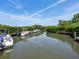 Beautiful canal view with boats docked, surrounded by lush greenery and clear skies at 8871 Fishermens Bay Dr, Sarasota, FL 34231