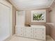 Walk-in closet with custom organization system and a view of tropical landscaping from the window at 8871 Fishermens Bay Dr, Sarasota, FL 34231
