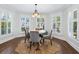 Cozy breakfast nook featuring plantation shutters, hardwood flooring, and a modern chandelier at 8871 Fishermens Bay Dr, Sarasota, FL 34231