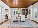 Elegant dining room featuring a wooden ceiling, chandelier, and a stylish area rug at 8871 Fishermens Bay Dr, Sarasota, FL 34231
