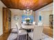 Elegant dining room features a wooden ceiling, chandelier lighting, and a table set for dinner at 8871 Fishermens Bay Dr, Sarasota, FL 34231