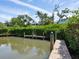 Waterfront property featuring a private dock with lush greenery and serene water views at 8871 Fishermens Bay Dr, Sarasota, FL 34231
