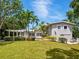 Rear exterior view showcasing a well-maintained lawn, pool area, and charming pergola at 8871 Fishermens Bay Dr, Sarasota, FL 34231