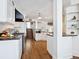 Open kitchen featuring stainless steel appliances, dark countertops, hardwood flooring, and modern white cabinetry at 8871 Fishermens Bay Dr, Sarasota, FL 34231