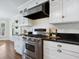 Gourmet kitchen with stainless steel range, custom cabinets, black granite countertops, and a built in vent at 8871 Fishermens Bay Dr, Sarasota, FL 34231