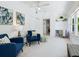 Bright living room with white walls, blue chairs, and a view of the built in shelves and desk at 8871 Fishermens Bay Dr, Sarasota, FL 34231