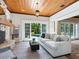 Warm living room with a stone fireplace, wooden ceiling, and French doors opening to the outdoors at 8871 Fishermens Bay Dr, Sarasota, FL 34231