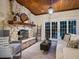 Inviting living room with a stone fireplace, wooden ceiling, and comfortable seating at 8871 Fishermens Bay Dr, Sarasota, FL 34231