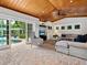 Inviting living room with a wooden ceiling, comfortable seating, and views of the outdoor pool at 8871 Fishermens Bay Dr, Sarasota, FL 34231