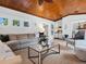 Comfortable living room featuring a wooden ceiling, stylish decor, and a glimpse of the kitchen at 8871 Fishermens Bay Dr, Sarasota, FL 34231
