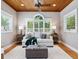 Cozy living room with tongue and groove ceiling, hardwood flooring, large windows with plantation shutters, and modern decor at 8871 Fishermens Bay Dr, Sarasota, FL 34231