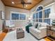 Cozy living room with wood floors, a beamed ceiling, and an abundance of natural light from shuttered windows at 8871 Fishermens Bay Dr, Sarasota, FL 34231