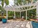 Outdoor patio area featuring a charming pergola with string lights and brick flooring, perfect for relaxing and entertaining at 8871 Fishermens Bay Dr, Sarasota, FL 34231