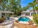 Backyard with a beautiful pool and patio area, surrounded by lush landscaping and a charming pergola at 8871 Fishermens Bay Dr, Sarasota, FL 34231