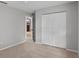 Carpeted bedroom with double doors, neutral paint, and an open view of the living area at 920 36Th W St, Bradenton, FL 34205