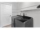 Laundry room with modern washer and dryer, shelving for storage, and a white door at 920 36Th W St, Bradenton, FL 34205