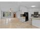Open-concept living and kitchen area with tile floors, stainless steel appliances, and ample natural light at 920 36Th W St, Bradenton, FL 34205