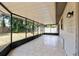 Covered screened in patio with light colored tile floor overlooks backyard at 920 36Th W St, Bradenton, FL 34205