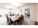 A wood dining table in an open-concept space leads to a well-lit living room and a view of the backyard at 104 Shoreland Dr, Osprey, FL 34229
