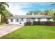 Charming single-story home featuring light blue shutters, a well-manicured lawn, and a concrete driveway at 104 Shoreland Dr, Osprey, FL 34229