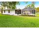 Rear exterior view of home with a screened-in pool and well-maintained lawn at 104 Shoreland Dr, Osprey, FL 34229