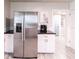 Spacious kitchen with stainless steel refrigerator, white cabinets, dark counters, and light wood-look flooring at 104 Shoreland Dr, Osprey, FL 34229