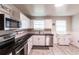 Bright kitchen featuring white cabinets, stainless steel appliances, and dark countertops with wood floors at 104 Shoreland Dr, Osprey, FL 34229