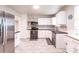Modern kitchen with stainless steel appliances, white cabinets, dark countertops, and wood-look flooring at 104 Shoreland Dr, Osprey, FL 34229