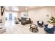 Bright living room featuring a gray sectional sofa, blue chairs, light floors, and a fireplace at 104 Shoreland Dr, Osprey, FL 34229