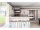 Covered outdoor kitchen featuring tiled countertops, grill, and seating for entertaining at 104 Shoreland Dr, Osprey, FL 34229