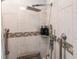Modern walk-in shower featuring a rainfall showerhead, handheld sprayer, and safety grab bars at 104 Shoreland Dr, Osprey, FL 34229