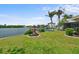 Landscaped backyard with waterfront views, a private dock, and lush green lawn at 10432 Sandpiper W Rd, Bradenton, FL 34209