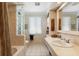Bright bathroom featuring tile flooring, block glass, and a vanity with ample counter space at 10432 Sandpiper W Rd, Bradenton, FL 34209