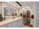Bright bathroom featuring a vanity with marble countertops, white cabinetry, and decorative shelving at 10432 Sandpiper W Rd, Bradenton, FL 34209