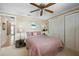 Cozy bedroom with a ceiling fan, closet and natural light from window at 10432 Sandpiper W Rd, Bradenton, FL 34209