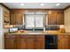 Well-lit kitchen with granite countertops, wooden cabinetry, and a ceramic tile backsplash at 10432 Sandpiper W Rd, Bradenton, FL 34209