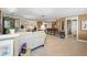 Open-concept living room with tile flooring, neutral tones, and seamless flow to the kitchen, great for entertaining at 10432 Sandpiper W Rd, Bradenton, FL 34209